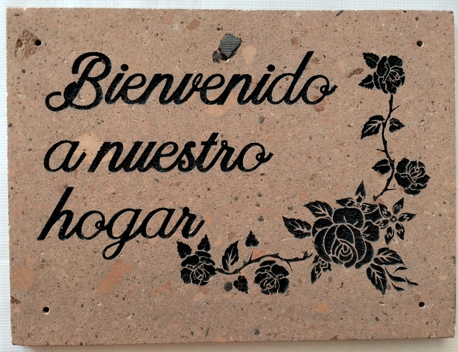 Placa conmemorativa con texto y diseño floral